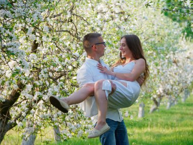 2020 bahçesindeki çiçek açan elma ağaçlarındaki genç adam ve kız.