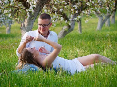 2020 bahçesindeki çiçek açan elma ağaçlarındaki genç adam ve kız.