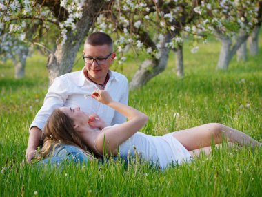 2020 bahçesindeki çiçek açan elma ağaçlarındaki genç adam ve kız.