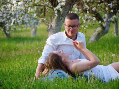 2020 bahçesindeki çiçek açan elma ağaçlarındaki genç adam ve kız.