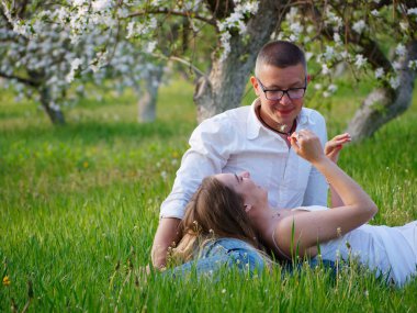 2020 bahçesindeki çiçek açan elma ağaçlarındaki genç adam ve kız.