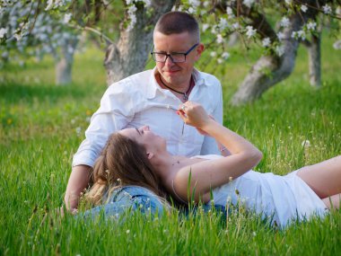 2020 bahçesindeki çiçek açan elma ağaçlarındaki genç adam ve kız.