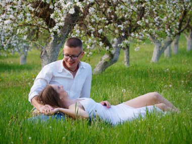 2020 bahçesindeki çiçek açan elma ağaçlarındaki genç adam ve kız.