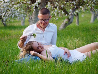 2020 bahçesindeki çiçek açan elma ağaçlarındaki genç adam ve kız.