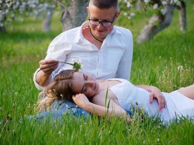 2020 bahçesindeki çiçek açan elma ağaçlarındaki genç adam ve kız.