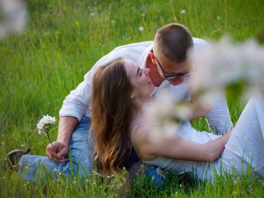 2020 bahçesindeki çiçek açan elma ağaçlarındaki genç adam ve kız.