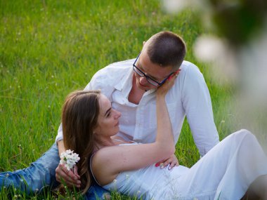 2020 bahçesindeki çiçek açan elma ağaçlarındaki genç adam ve kız.