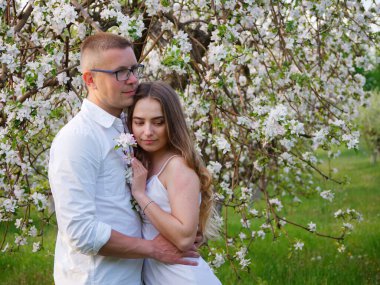 2020 bahçesindeki çiçek açan elma ağaçlarındaki genç adam ve kız.