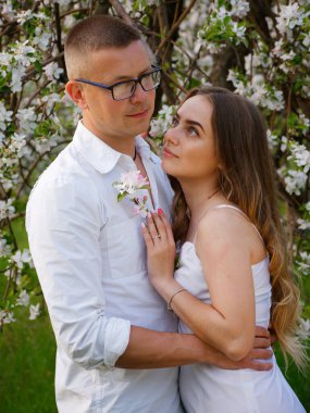 2020 bahçesindeki çiçek açan elma ağaçlarındaki genç adam ve kız.