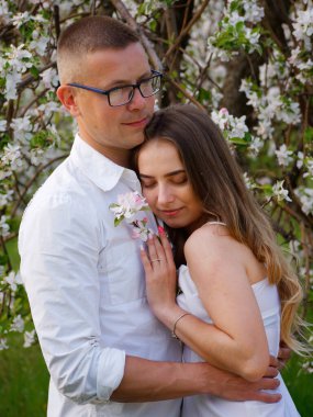 2020 bahçesindeki çiçek açan elma ağaçlarındaki genç adam ve kız.