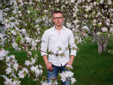 2020 'de çiçek açan bir bahçede genç ve yakışıklı bir ziraat uzmanı.