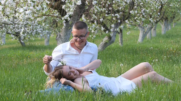 2020 bahçesindeki çiçek açan elma ağaçlarındaki genç adam ve kız.