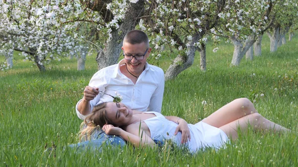 2020 bahçesindeki çiçek açan elma ağaçlarındaki genç adam ve kız.