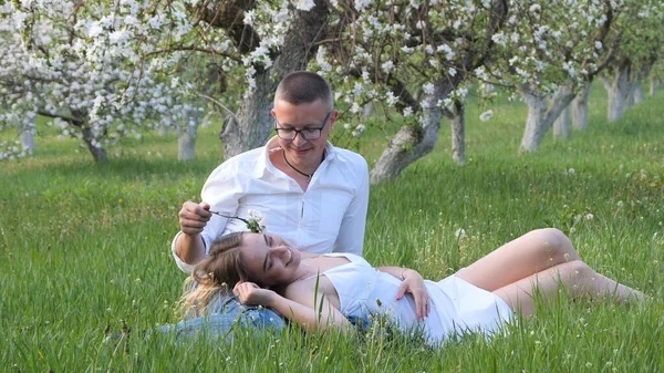 2020 bahçesindeki çiçek açan elma ağaçlarındaki genç adam ve kız.