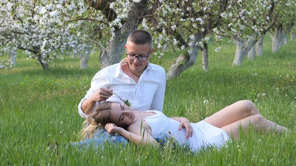 2020 bahçesindeki çiçek açan elma ağaçlarındaki genç adam ve kız.