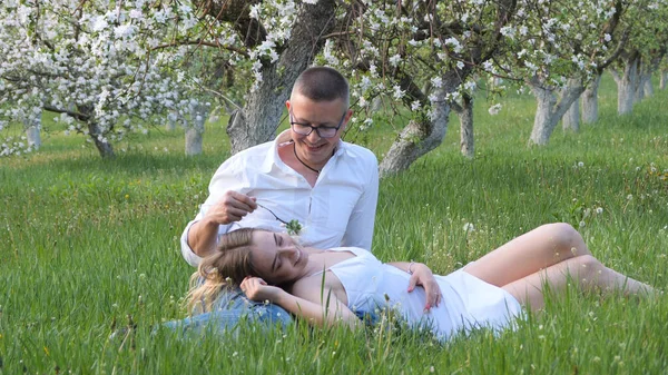 2020 bahçesindeki çiçek açan elma ağaçlarındaki genç adam ve kız.