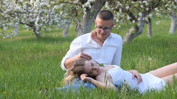 2020 bahçesindeki çiçek açan elma ağaçlarındaki genç adam ve kız.