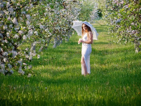 庭でリンゴの木を咲かせている白い傘の女の子2020 — ストック写真