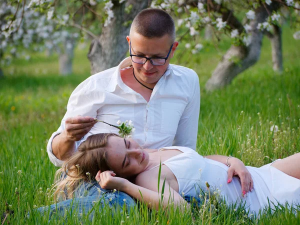 2020 bahçesindeki çiçek açan elma ağaçlarındaki genç adam ve kız.