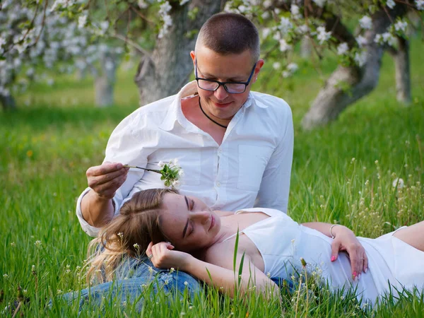 庭でリンゴの木を咲かせている若い男と女の子2020 — ストック写真