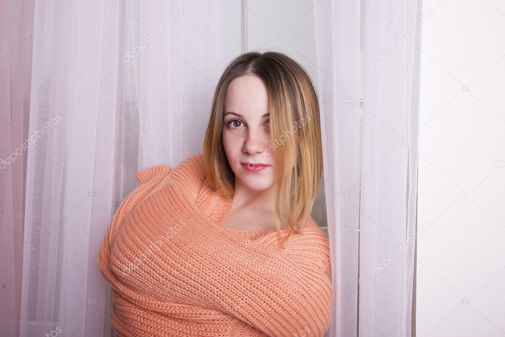 Lovely young woman in a peach-colored pullover