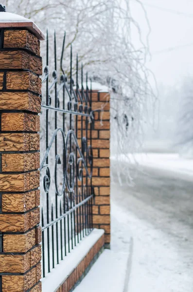 Snowy ścieżki w pobliżu ogrodzenia z cegły — Zdjęcie stockowe