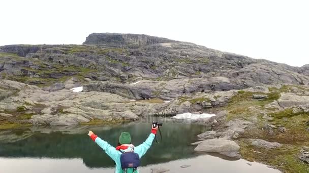 Chica con cámara se encuentra entre las rocas — Vídeos de Stock