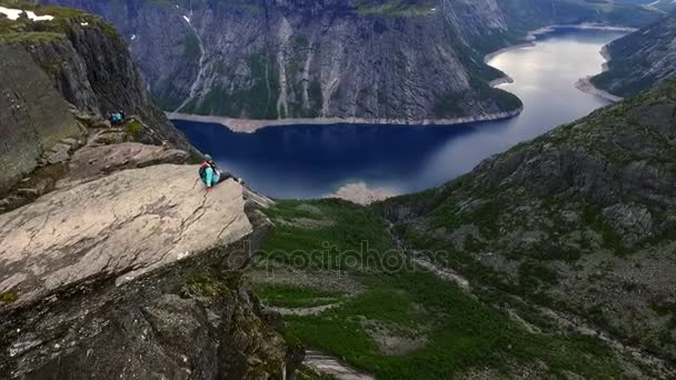 Flickan sitter på kanten av en klippa — Stockvideo