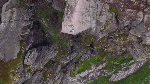 Mädchen am Rande einer Klippe. Norwegen. — Stockvideo