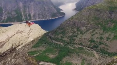 Trolltunga. Taş kenarında oturan adam