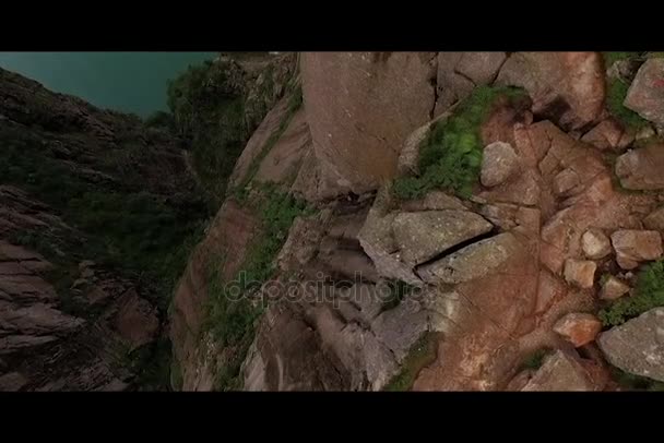 Norsko. Hory. Dívka sedí na okraji útesu. Pohled z dron — Stock video