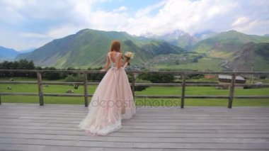 Güzel gelin bir buket çiçek dağ manzarası, bir arka plan ile. Gürcistan. 