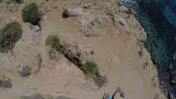 Два парня стоят на скале на берегу моря — стоковое видео