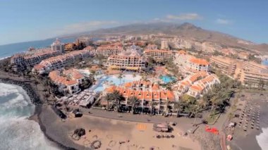 Dağlar arka planda sahilde şık otel.