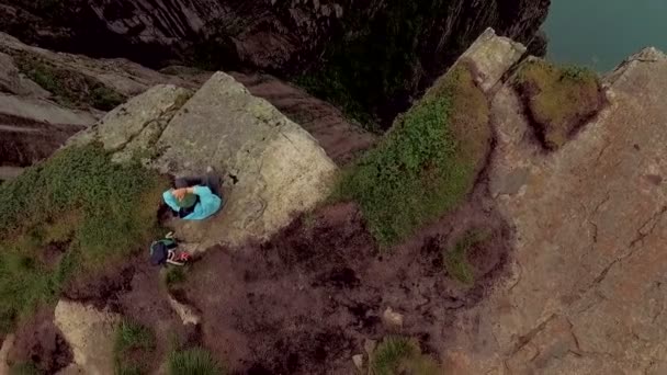 Spektakuläre Landschaft der Tierwelt. Mädchen am Rande einer Klippe. Trolltunga — Stockvideo