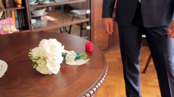 Man takes a box and flowers from the table — Stock Video