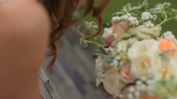 Prachtige bruid blonde met een boeket van bloemen — Stockvideo