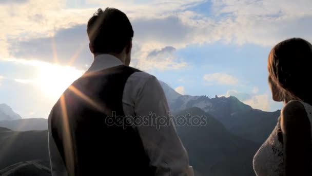 Silueta milující pár na pozadí zapadajícího slunce, hory. — Stock video