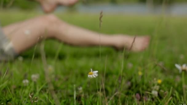 Girl is resting on the meadow near the river — Stock Video