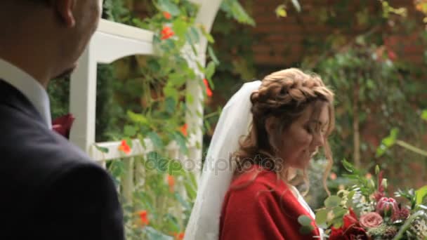 Portrait of a young couple in love in a garden near a gazebo — Stock Video