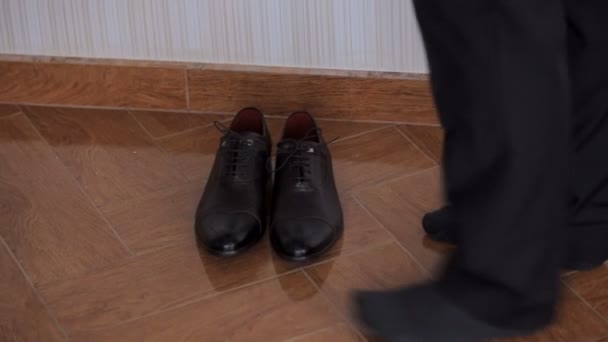 Man raising shoes with shoelaces from floor — Stock Video