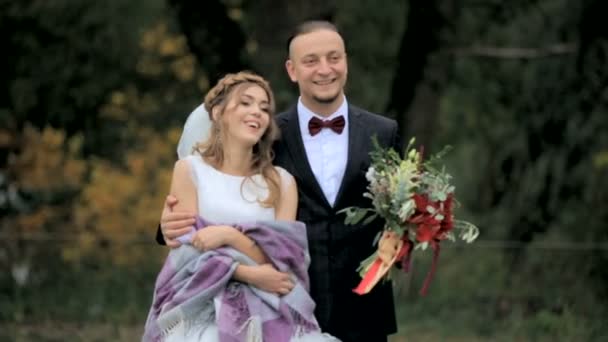 Schönes Brautpaar steht im Park — Stockvideo