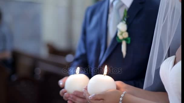 Noiva e noivo segurando velas na igreja — Vídeo de Stock