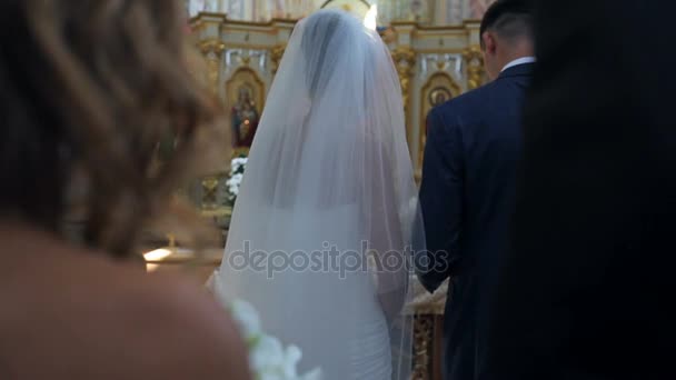 Наречений і наречений стоять в церкві — стокове відео
