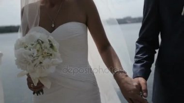 Gelin ve damat el ele tutuşuyorlar.