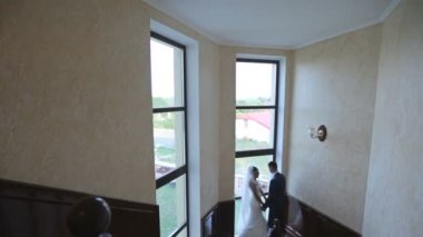 Gelin ve damat otel lobisinde ayakta 