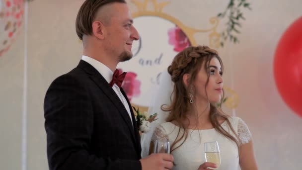 Jonggehuwden wijnglazen met champagne bedrijf in handen — Stockvideo
