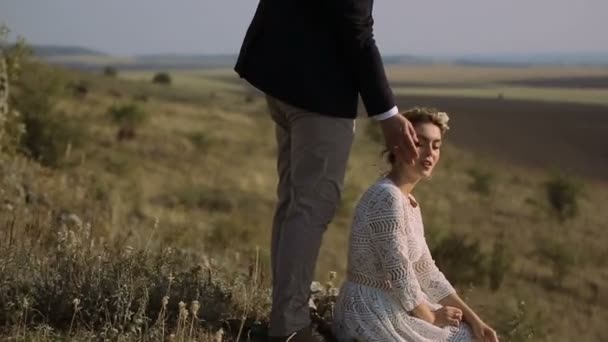 Bela noiva e noivo descansando no campo — Vídeo de Stock