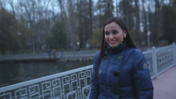 Femme marchant le long du pont dans le parc — Video