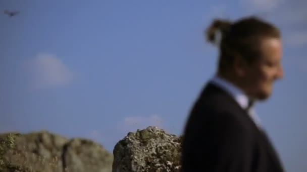 Brudgummen står nära stenar — Stockvideo